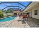 Beautiful screened-in pool area with bar seating, a hot tub, and brick pavers at 3050 Rivershore Ln, Port Charlotte, FL 33953