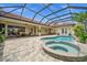 Relax in this refreshing pool and spa surrounded by brick pavers and comfortable seating area under the screened enclosure at 3050 Rivershore Ln, Port Charlotte, FL 33953