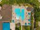 Aerial top-down view of a resort-style swimming pool with adjacent clubhouse and lush landscaping at 3050 Rivershore Ln, Port Charlotte, FL 33953
