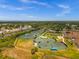 Aerial view of multiple tennis courts with shade canopies and well-maintained landscaping in a vibrant community at 3050 Rivershore Ln, Port Charlotte, FL 33953