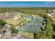 This aerial shot showcases tennis courts in a well-maintained community, surrounded by greenery and parking areas at 3412 Grand Vista Ct # 202, Port Charlotte, FL 33953