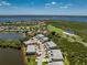 Scenic aerial of a multi-Gathering home with lake views, golf course, mature landscaping, and a clear blue sky at 3412 Grand Vista Ct # 202, Port Charlotte, FL 33953