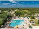 A high-angle view of a community pool area, complete with lounge chairs, umbrellas, and lush landscaping at 3412 Grand Vista Ct # 202, Port Charlotte, FL 33953