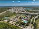 Aerial view of community amenities, including pool, clubhouse, and tennis courts, within a scenic landscape at 3412 Grand Vista Ct # 202, Port Charlotte, FL 33953