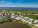 Aerial view showcasing a multi-Gathering home within a community near a lake, golf course and landscaping at 3412 Grand Vista Ct # 202, Port Charlotte, FL 33953