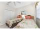 Bright bedroom showcasing twin beds with tropical bedding, a white closet door, and a cozy ambiance at 3412 Grand Vista Ct # 202, Port Charlotte, FL 33953