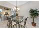 Bright dining room features tile flooring, a modern chandelier and access to the kitchen and living area at 3412 Grand Vista Ct # 202, Port Charlotte, FL 33953