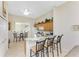 Open kitchen with breakfast bar, wood cabinetry, white appliances and adjacent breakfast nook for casual dining at 3412 Grand Vista Ct # 202, Port Charlotte, FL 33953