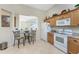 Kitchen offers white appliances, wood cabinets, a pass-through window and a breakfast nook for additional seating at 3412 Grand Vista Ct # 202, Port Charlotte, FL 33953