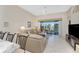 Inviting living room with sliding glass doors to screened lanai with views of the lake and outdoor seating at 3412 Grand Vista Ct # 202, Port Charlotte, FL 33953