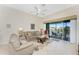 Bright living room features high ceilings, sliding glass doors to screened lanai and a tranquil view of the lake at 3412 Grand Vista Ct # 202, Port Charlotte, FL 33953