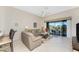 Inviting living room with sliding glass doors to screened lanai with views of the lake and outdoor seating at 3412 Grand Vista Ct # 202, Port Charlotte, FL 33953