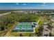 Aerial view of community tennis and pickleball courts, set against a backdrop of lush trees and residences at 3412 Grand Vista Ct # 202, Port Charlotte, FL 33953