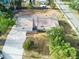 An aerial view shows the house with a driveway and lawn on a sunny day, surrounded by green trees at 3502 N Lincoln Ave, Tampa, FL 33607