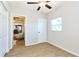 Bright bedroom with wood-look flooring, a ceiling fan, and a view into the kitchen at 3502 N Lincoln Ave, Tampa, FL 33607
