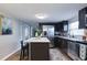 Well-lit kitchen with stainless steel appliances, breakfast bar with stools, and modern finishes at 3502 N Lincoln Ave, Tampa, FL 33607