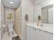 Well-lit bathroom with a vanity, a toilet, and a shower behind a striped curtain at 3715 Albacete Cir # 93, Punta Gorda, FL 33950