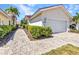 Beautiful home showcasing a brick driveway, lush greenery, and attached garage at 3715 Albacete Cir # 93, Punta Gorda, FL 33950