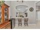 Cozy seating at a kitchen bar with a view of the dining area and decorative display cabinet at 3715 Albacete Cir # 93, Punta Gorda, FL 33950