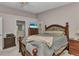 Cozy main bedroom with a wooden bed frame, soft carpet, and a view into the bathroom and a sunny window at 3715 Albacete Cir # 93, Punta Gorda, FL 33950