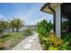 A home's beautifully landscaped backyard features a stone walkway leading to waterfront views at 376 Portofino Dr, Punta Gorda, FL 33950