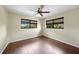 Bedroom offers wood floors, ceiling fan, and natural light from two windows at 376 Portofino Dr, Punta Gorda, FL 33950