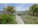 A stone walkway in a home's backyard leads to serene waterfront views and a private dock at 376 Portofino Dr, Punta Gorda, FL 33950