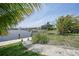 A backyard's stone walkway leads to a waterfront with boat dock and lift, fringed by palm trees at 376 Portofino Dr, Punta Gorda, FL 33950