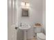 Clean half bathroom featuring a pedestal sink and modern lighting fixtures at 3800 Bal Harbor Blvd # 415, Punta Gorda, FL 33950