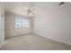 Neutral-toned bedroom featuring carpet, a ceiling fan, and large window with shutters at 3800 Bal Harbor Blvd # 415, Punta Gorda, FL 33950