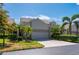 Front exterior of two-story home with lush landscaping and two-car garage at 3800 Bal Harbor Blvd # 415, Punta Gorda, FL 33950