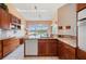 Bright kitchen with wood cabinets, granite countertops, and breakfast nook overlooking waterfront views at 3800 Bal Harbor Blvd # 415, Punta Gorda, FL 33950