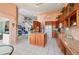 Large kitchen with island, wood cabinets, granite counters, and views to the living area at 3800 Bal Harbor Blvd # 415, Punta Gorda, FL 33950