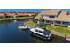 Waterfront home with boat docked in the canal, lush green lawn, and views of neighboring houses at 3800 Bal Harbor Blvd # 415, Punta Gorda, FL 33950