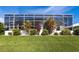 Manicured backyard showcasing a white screened-in lanai and vibrant landscaping, ideal for relaxation at 3907 San Pietro Ct, Punta Gorda, FL 33950