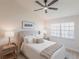 Cozy bedroom with a cushioned headboard and a ceiling fan, offering both comfort and style for a restful retreat at 3907 San Pietro Ct, Punta Gorda, FL 33950
