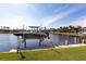 Dock with a boat lift on a sunny day, perfect for waterfront living and boating enthusiasts at 3907 San Pietro Ct, Punta Gorda, FL 33950