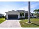 Charming home featuring a well-manicured lawn, mature palm trees, and an attached two-car garage at 3907 San Pietro Ct, Punta Gorda, FL 33950