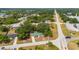 Aerial view of a home with a green metal roof surrounded by lush trees and a nearby church at 4009 Yucatan Cir, Port Charlotte, FL 33948