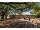 Spacious backyard featuring a fire pit, mature trees, and patio seating, perfect for outdoor gatherings at 4009 Yucatan Cir, Port Charlotte, FL 33948