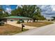 Charming single-story home with a green metal roof and landscaped front yard at 4009 Yucatan Cir, Port Charlotte, FL 33948