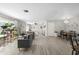 Open-concept living area with wood flooring, comfortable seating, and natural light from large windows at 4009 Yucatan Cir, Port Charlotte, FL 33948