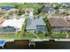 Aerial view of a waterfront home with a screened pool, dock, and lush landscaping near serene waterways at 5010 La Costa Island Ct, Punta Gorda, FL 33950