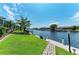 Beautiful waterfront backyard featuring a lush lawn, canal view, and a charming stone path at 5010 La Costa Island Ct, Punta Gorda, FL 33950