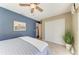 Bedroom with blue accent wall, closet, and a fan at 5010 La Costa Island Ct, Punta Gorda, FL 33950
