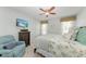 Bedroom with ceiling fan, a TV, comfortable bed, and an armchair at 5010 La Costa Island Ct, Punta Gorda, FL 33950