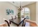 Elegant dining room featuring a chandelier, large arched window, and seating for six, perfect for Gathering gatherings at 5010 La Costa Island Ct, Punta Gorda, FL 33950