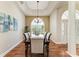 Beautiful dining room featuring a tray ceiling, chandelier, and a large arched window providing ample natural light at 5010 La Costa Island Ct, Punta Gorda, FL 33950