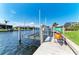 Waterfront view featuring a boat lift, kayaks, and clear blue water under a sunny sky at 5010 La Costa Island Ct, Punta Gorda, FL 33950