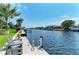 Dock featuring chairs, a ladder, and a picturesque view of the serene canal and waterfront homes at 5010 La Costa Island Ct, Punta Gorda, FL 33950